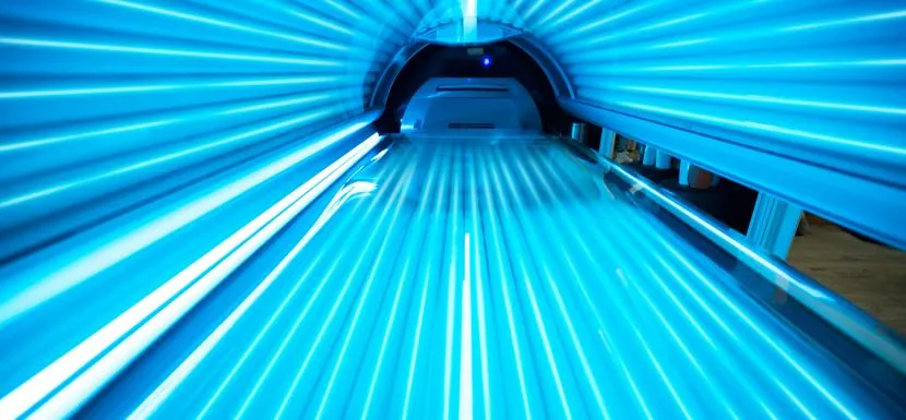 A close view of the illuminated tubes inside a lay-down sunbed